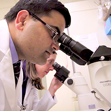 Researcher looking into microscope ? Breakthroughs to a Cure